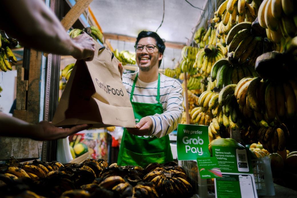 Smiling shopkeeper handing over a delivery order
